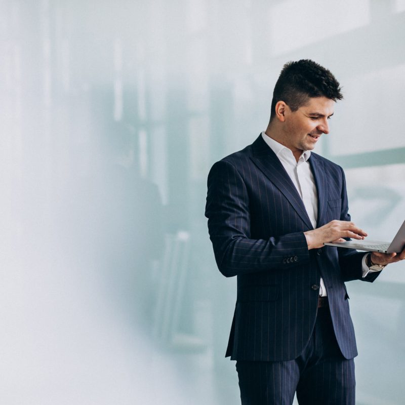 Young handsome business man with laptop in office